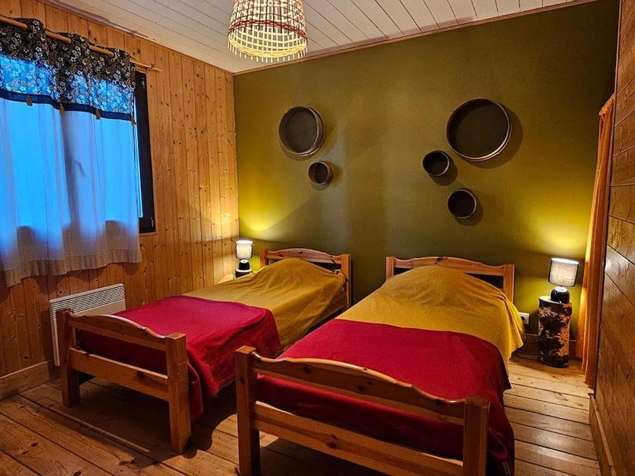 1 dormitorio con 2 camas y una pared con espejos en Le Fayard - Chalet avec terrasse, en Mélisey