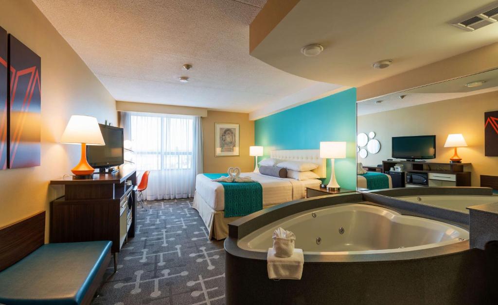 a hotel room with a tub and a bed at Howard Johnson Plaza by Wyndham by the Falls Niagara Falls in Niagara Falls