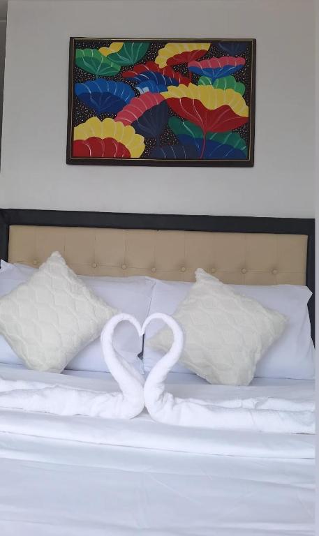 two swans forming a heart on top of a bed at Cozy Staycation in Manila