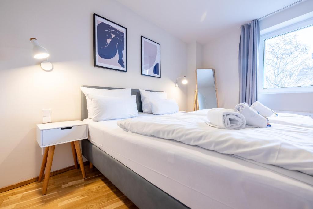 a large white bed in a room with a window at BRIGHT Leipzig Zentrum-West Stadion in Leipzig