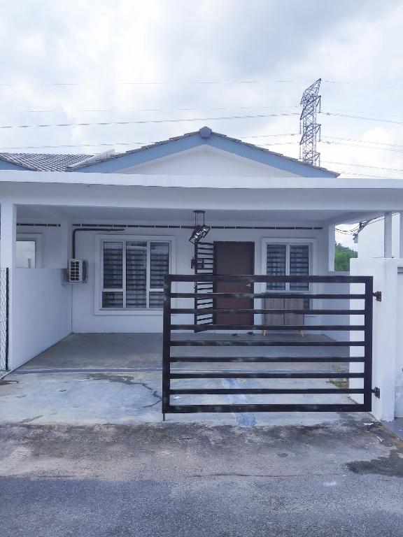 a white house with a gate in front of it at De' Balok Homestay in Kuantan