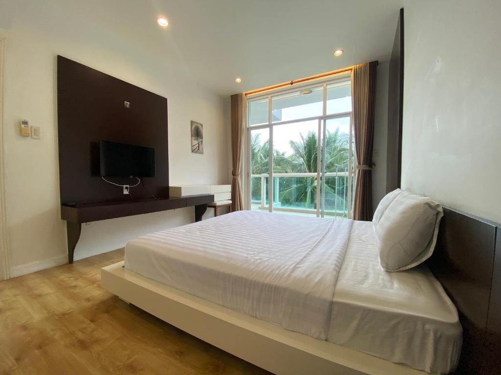 une chambre avec un grand lit et une fenêtre dans l'établissement Sealinks Ocean Vista, à Ấp Ngọc Hải