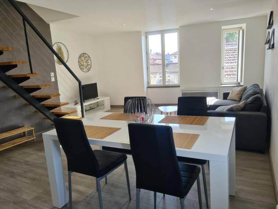 un salon avec une table et des chaises blanches dans l'établissement Appartement À deux pas de tout, à Issoire