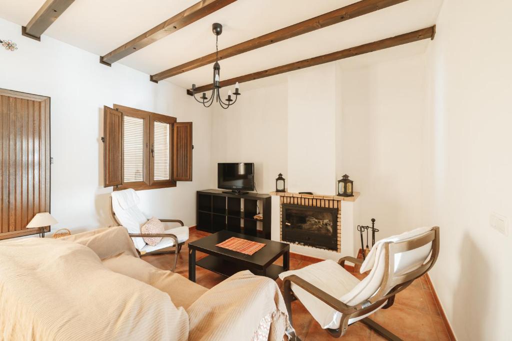 a living room with a couch and a fireplace at Casa Higuera de la Sierra in Higuera de la Sierra