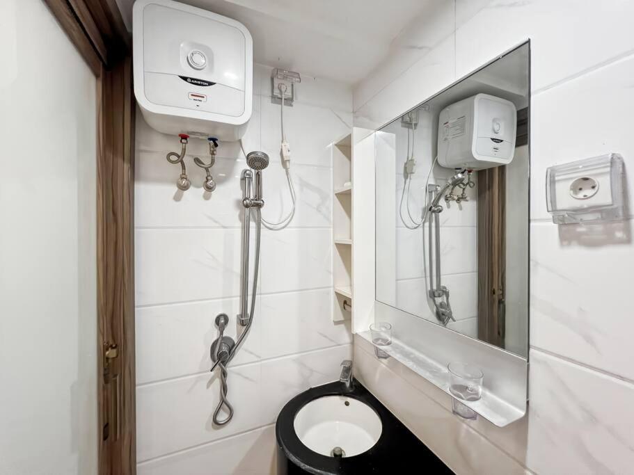 a bathroom with a toilet and a mirror at Cozy Studio Skyhouse Apt near ICE BSD with pool & Gym by 2ndHome in Cilenggang