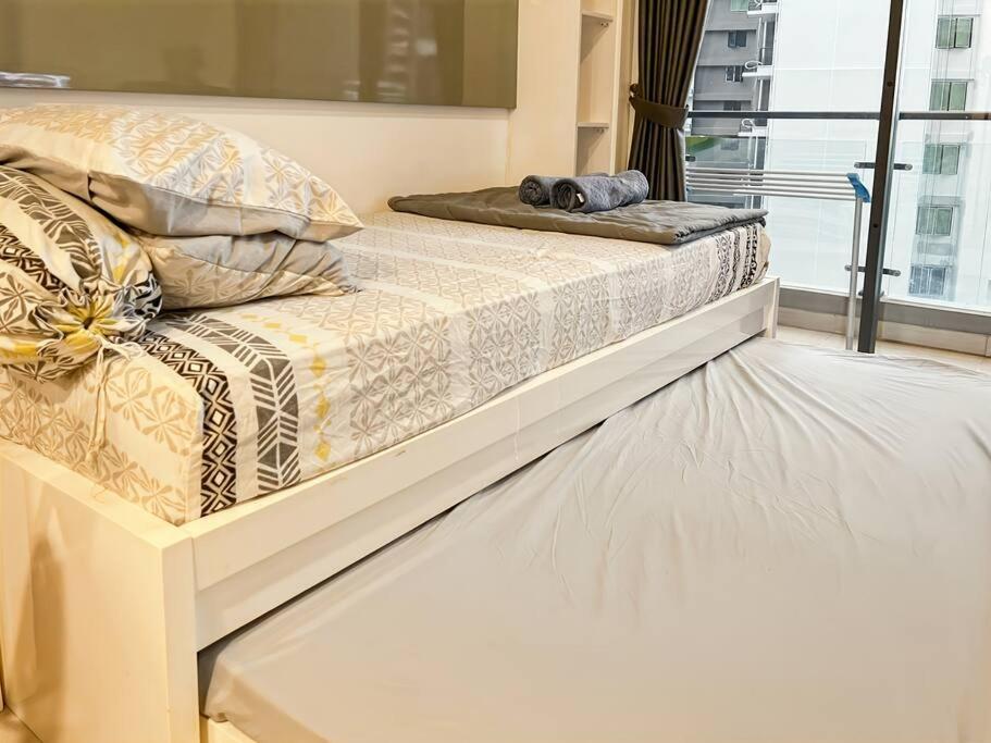 two beds in a room with a window at Cozy Studio Skyhouse Apt near ICE BSD with pool & Gym by 2ndHome in Cilenggang
