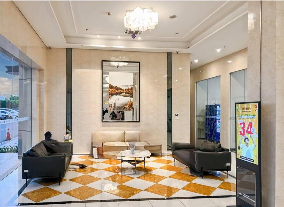 a lobby with couches and a table in a building at Cozy Studio Skyhouse Apt near ICE BSD with pool & Gym by 2ndHome in Cilenggang
