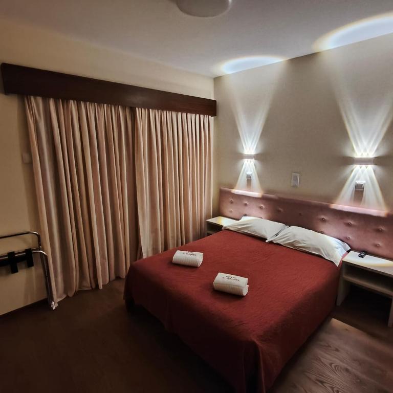 a bedroom with a red bed with two towels on it at Hotel S. Gabriel in Porto