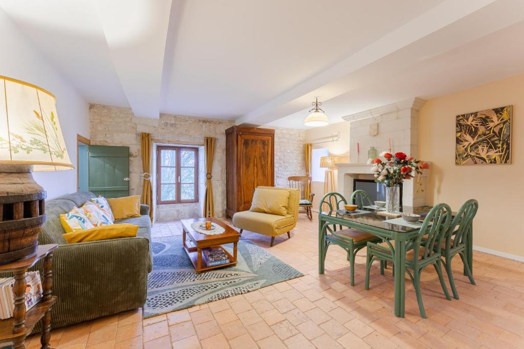 a living room with a couch and a table at Gite de la ferme du château 1 - Appt climatisé in Denezé-sous-Doué