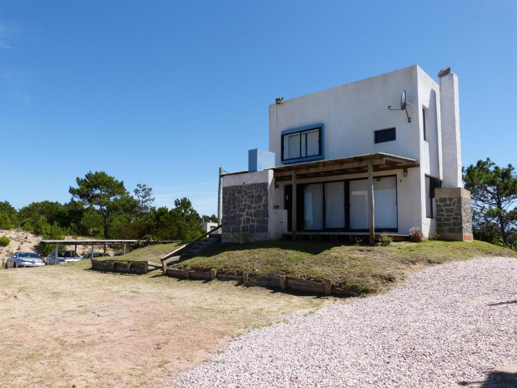 una casa blanca en la cima de una colina con césped en El Vuelo, en Punta del Diablo