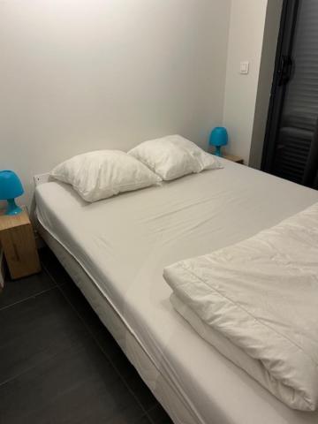 a white bed with two pillows on top of it at Chambre Au Trèfle Dort in Châtel-Guyon