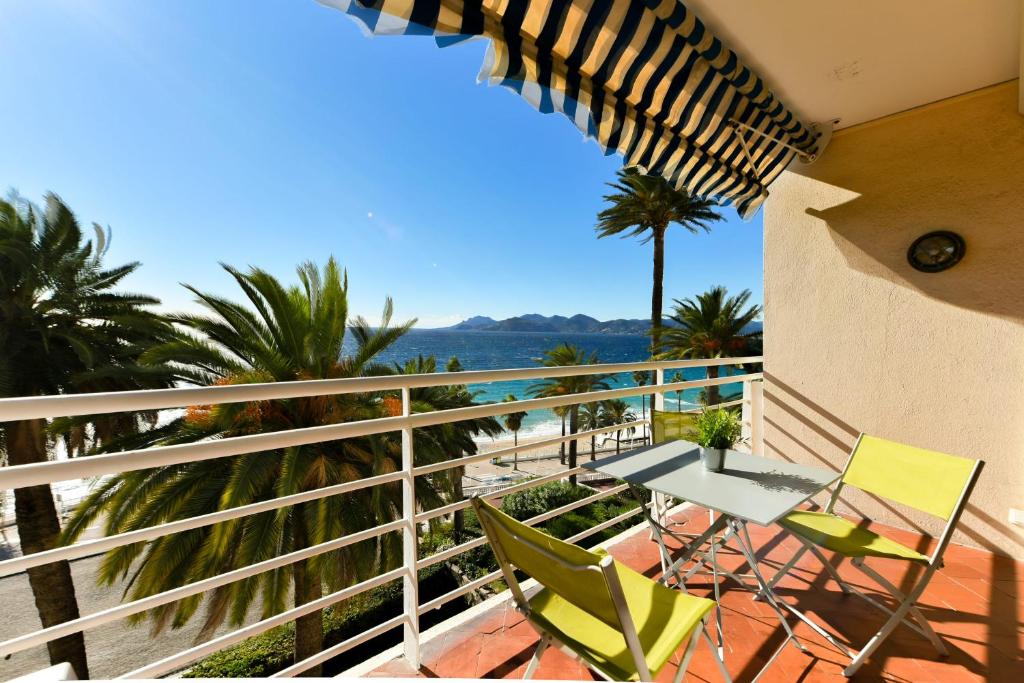 un balcon avec une table et des chaises et l'océan dans l'établissement LA BELLE VUE mer avec joli balcon et parking, à côté des plages et du centre-ville, à Cannes