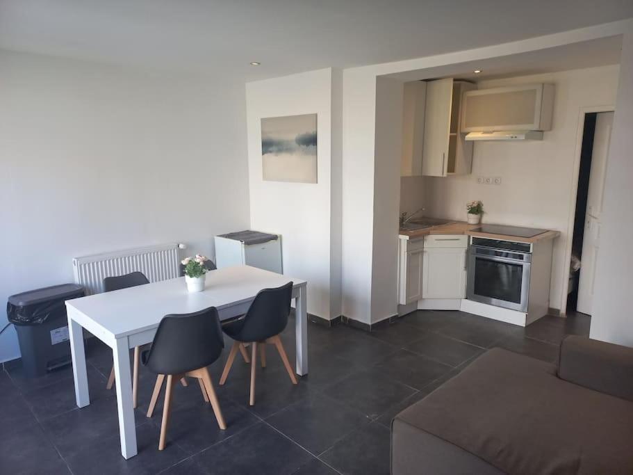 un salon avec une table et des chaises et une cuisine dans l'établissement Appt N1 Motte T2 Calme et Agréable, à Tourcoing
