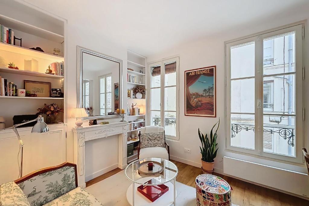 - un salon avec une table et quelques fenêtres dans l'établissement A cosy haven in Versailles charm and comfort, à Versailles