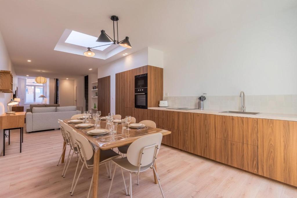 a kitchen and dining room with a table and chairs at Maison 3 chambres et 2 salle de bain avec jardin in Tourcoing