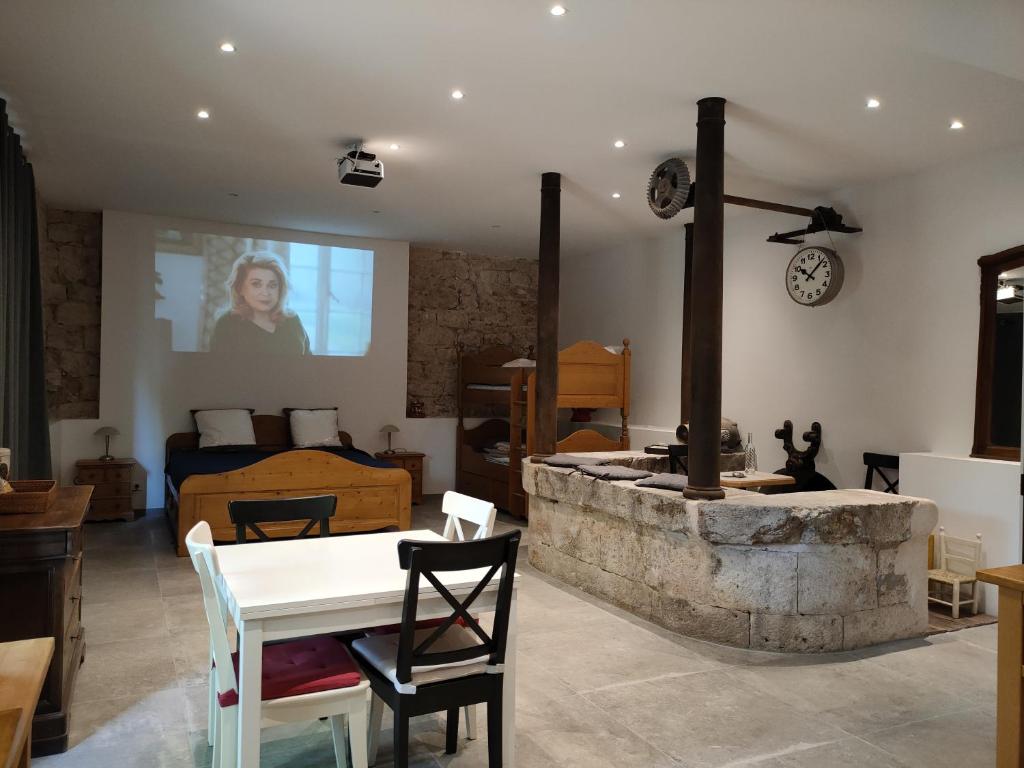 Cette chambre dispose d'une table et d'une cheminée en pierre. dans l'établissement Gites du Longevent Appartement du Moulin Pérouges, à Meximieux