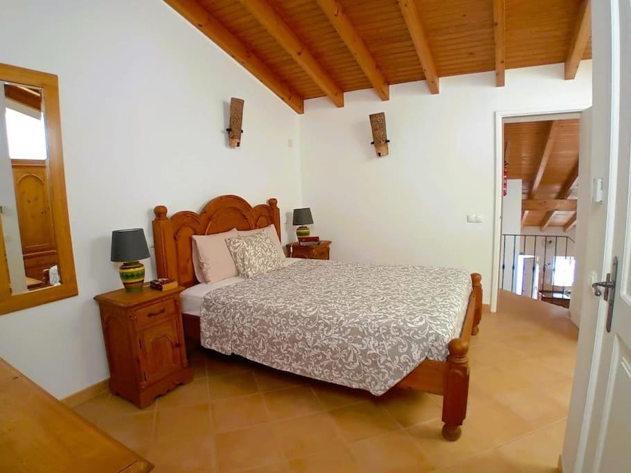 a bedroom with a bed and a wooden head board at Casa Roma in Raposeira