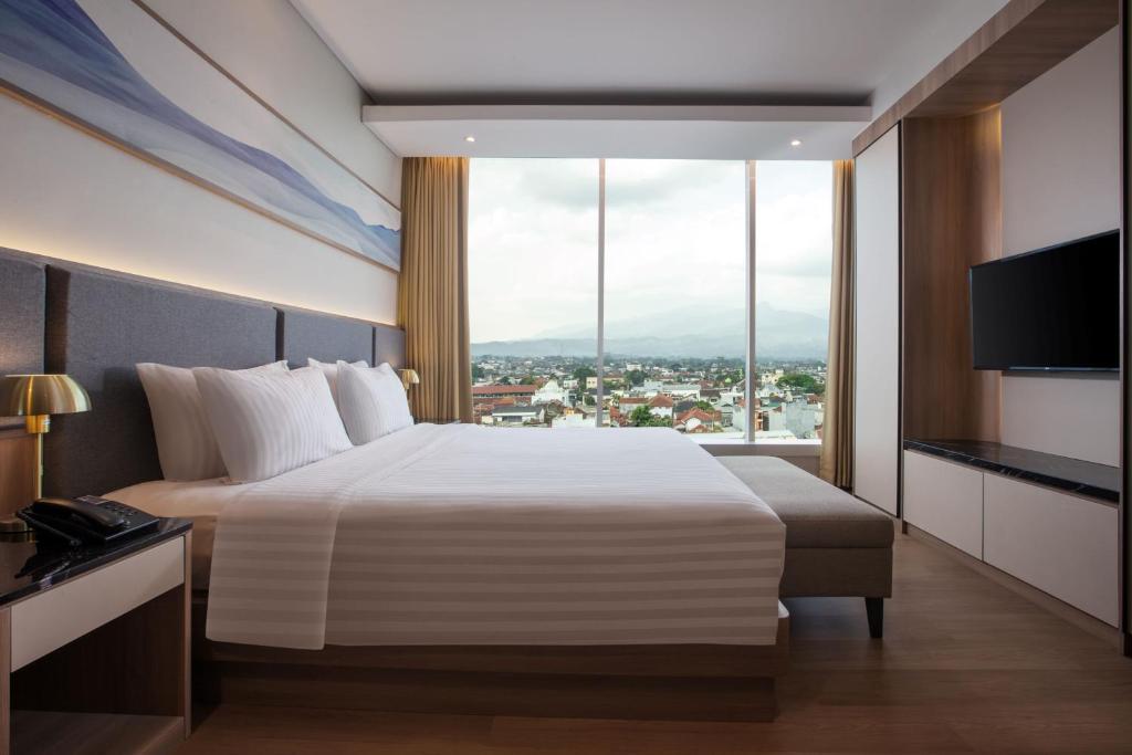 Postel nebo postele na pokoji v ubytování Hotel Santika Tasikmalaya