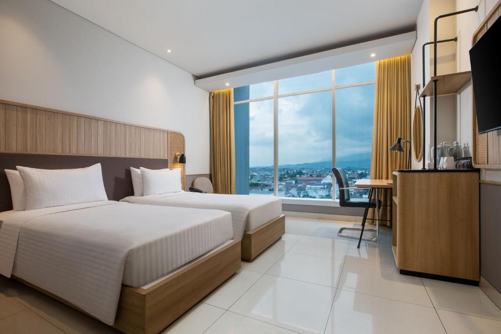 Postel nebo postele na pokoji v ubytování Hotel Santika Tasikmalaya