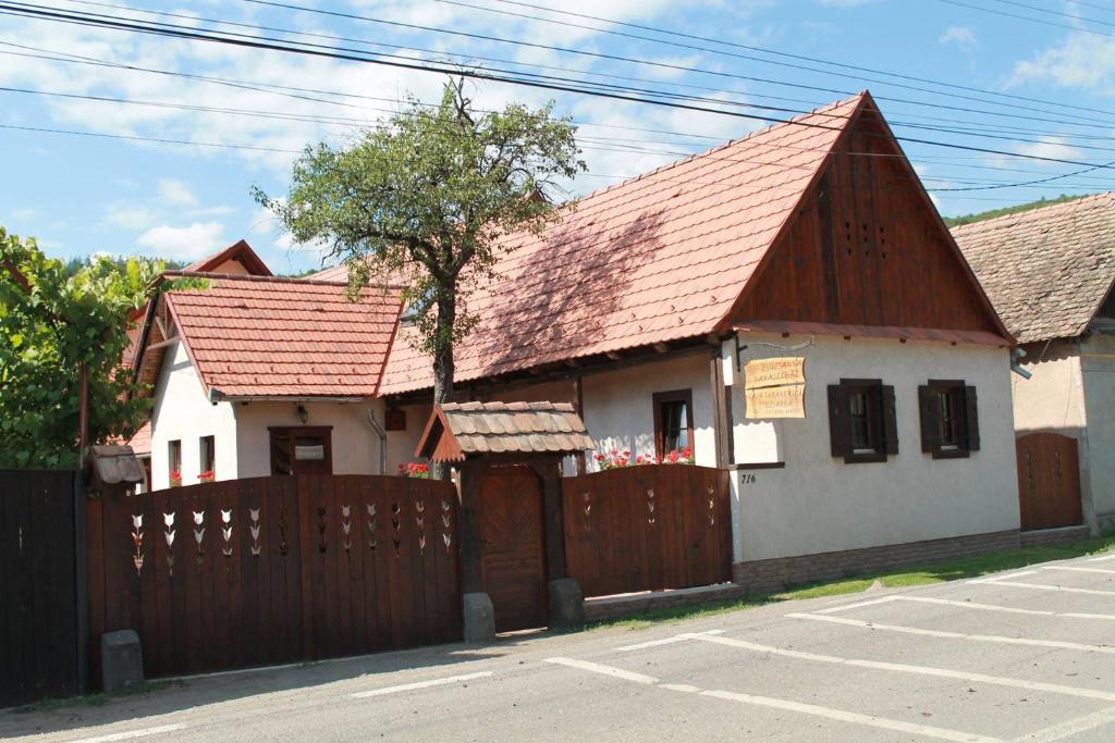 a small house with a wooden fence next to it at Zsuzsanna Paraszthaz in Praid