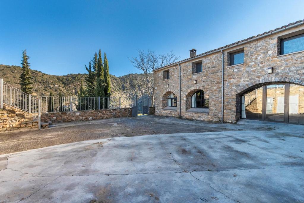 an empty parking lot in front of a brick building at Rectoria de Claverol in Claverol