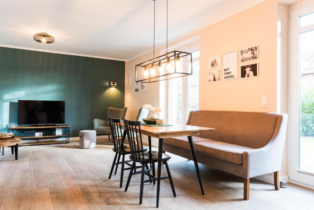 ein Wohnzimmer mit Tisch und Stühlen und einem Fernseher in der Unterkunft Backhaus 2 in Staberdorf