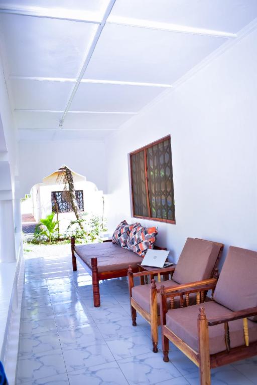 a living room with two chairs and a table at Private Villa & Tropical Garden Cottages near Bofa Beach - by Mango Tree Cottages Kilifi in Kilifi