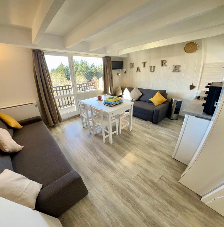 un salon avec un canapé et une table dans l'établissement Location appartement Chamrousse 1650 - Superbe vue, à Chamrousse