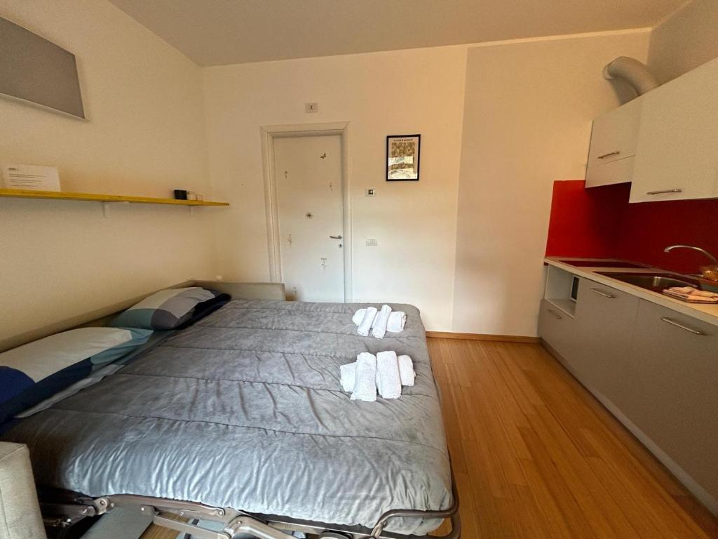 mały pokój z łóżkiem i kuchnią w obiekcie Luoghi Comuni Porta Palazzo w Turynie