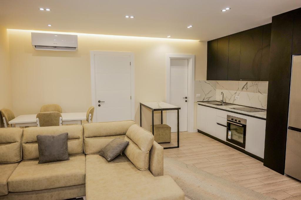 a living room with a couch and a kitchen at Vollgaapartment2 in Durrës