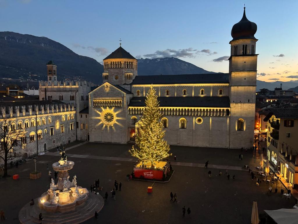 ein Gebäude mit einem Weihnachtsbaum davor in der Unterkunft Attico sul Duomo in Trient