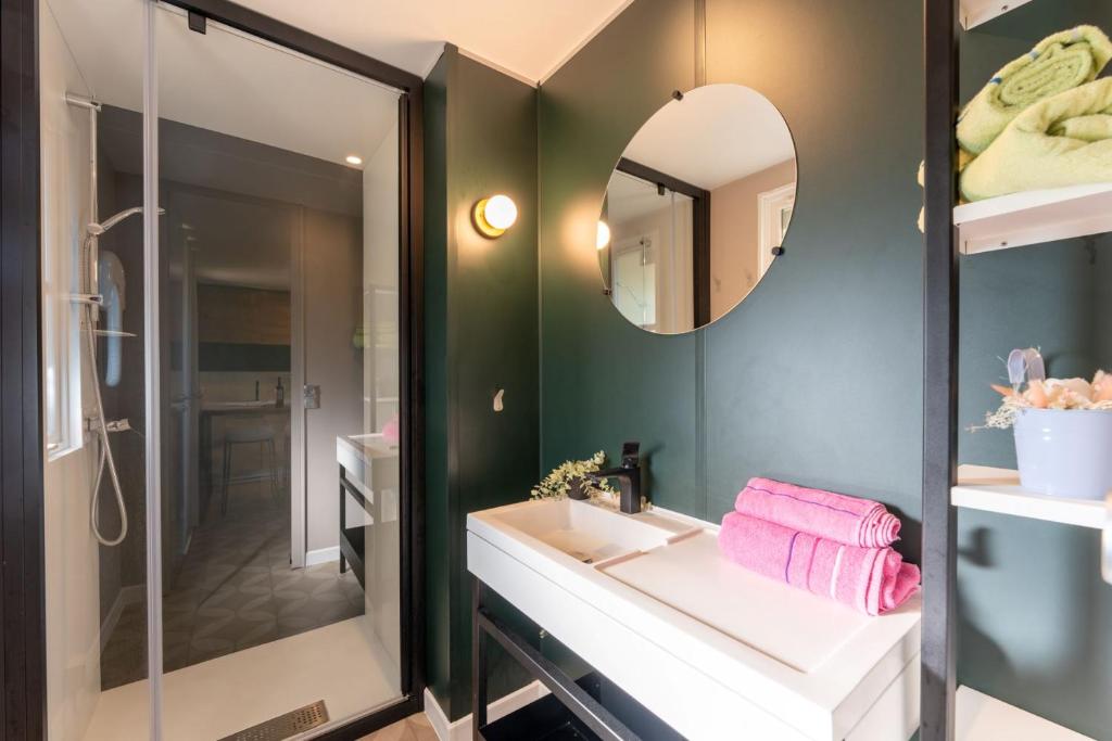 une salle de bain avec un lavabo et un miroir dans l'établissement CAMPING LES OURMES, à Hourtin