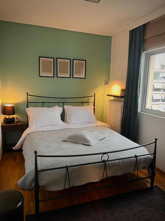 ein Schlafzimmer mit einem großen Bett und einem Fenster in der Unterkunft 19 Αri in Tríkala