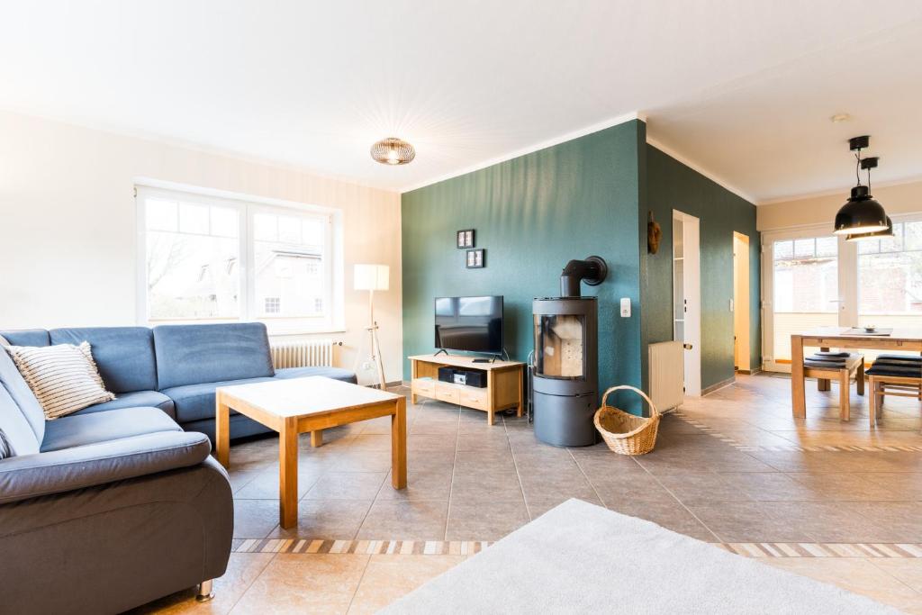 ein Wohnzimmer mit einem blauen Sofa und einem Tisch in der Unterkunft Omas Haus in Staberdorf