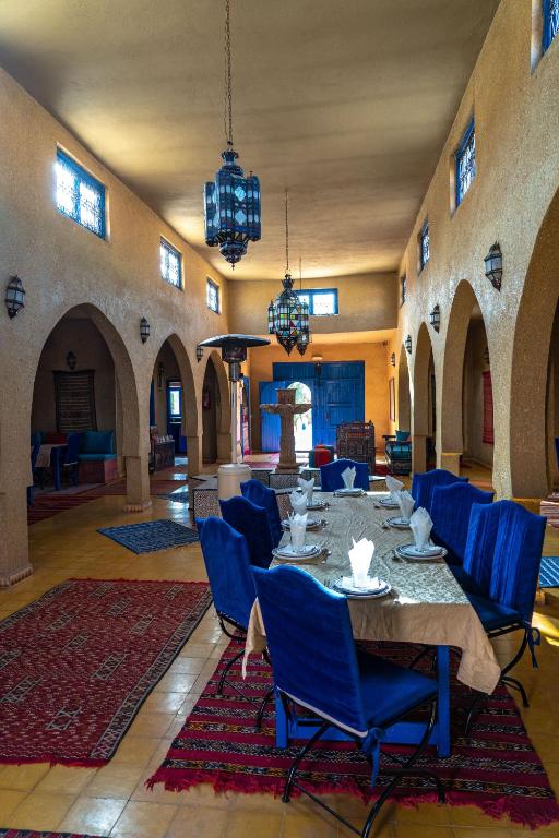 une salle à manger avec une table et des chaises bleues dans l'établissement Hotel Riad Ali, à Merzouga 91 autres photos