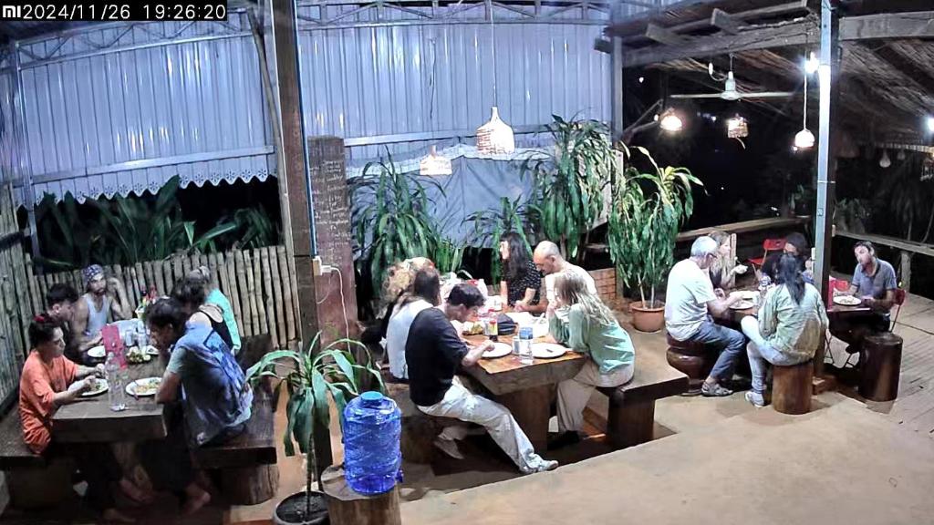 a group of people sitting at tables in a restaurant at FamilyHouse & Trekking in Banlung