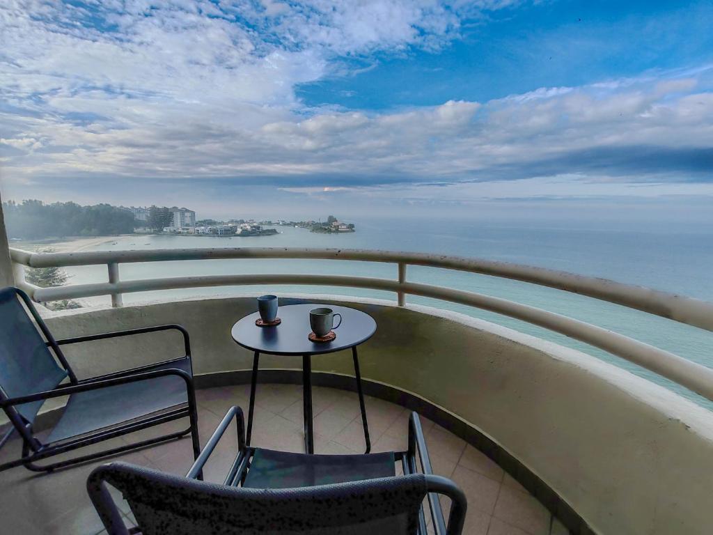 Una mesa y sillas en un balcón con vista al mar. en 'Sunny Seaview' at Regency corner unit with 2 carpark by Shine Stay, en Port Dickson