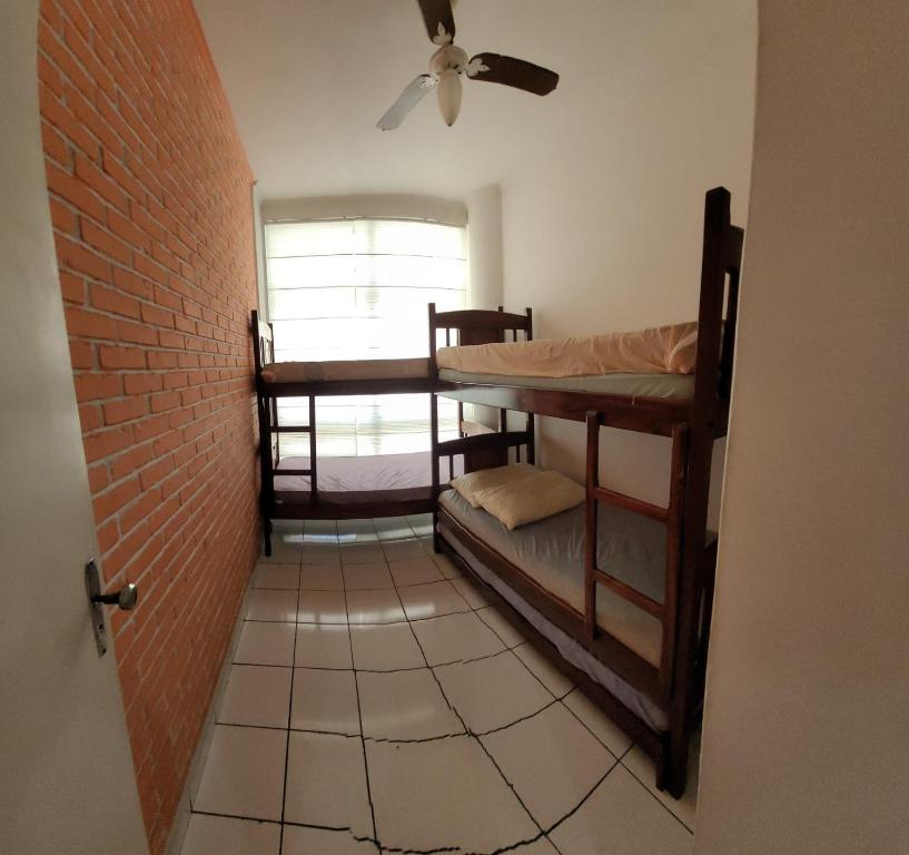 a hallway with two bunk beds and a brick wall at Apart511 in Santos