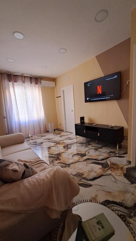 un salon avec une télévision au mur dans l'établissement Nel Cuore Di Napoli, à Naples