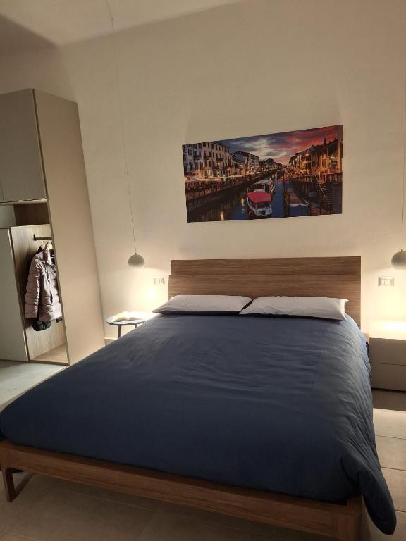 a bedroom with a bed and a painting on the wall at CasaManù in Cesano Maderno