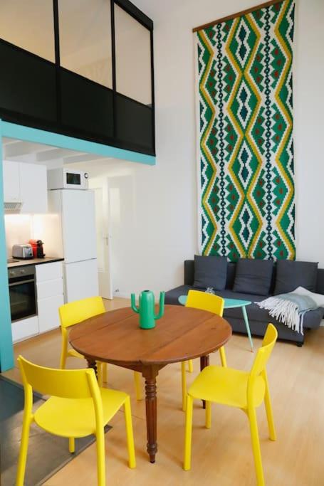 un salon avec une table et des chaises jaunes dans l'établissement Monnaie,Vieux-Lille, Unique, Neo-Vintage, à Lille