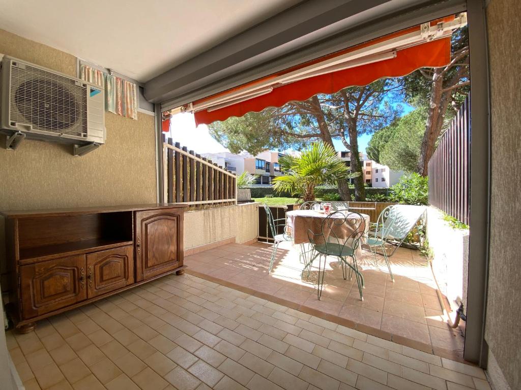 un patio avec une table et des chaises sur un balcon dans l'établissement Sol-y-Days Los Amigos, Studio 4 couchages en rez-de-jardin, avec grande terrasse et parking, à 250m de la plage, au Grau-du-Roi
