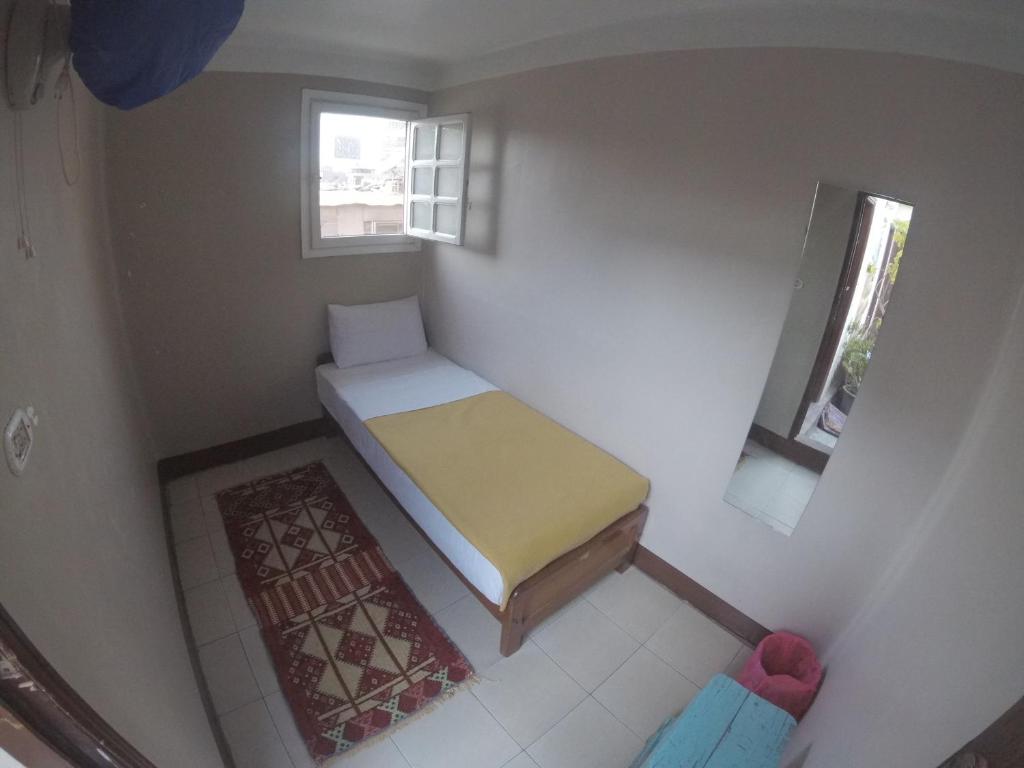 a small bedroom with a bed and a window at Dahab Hostel in Cairo