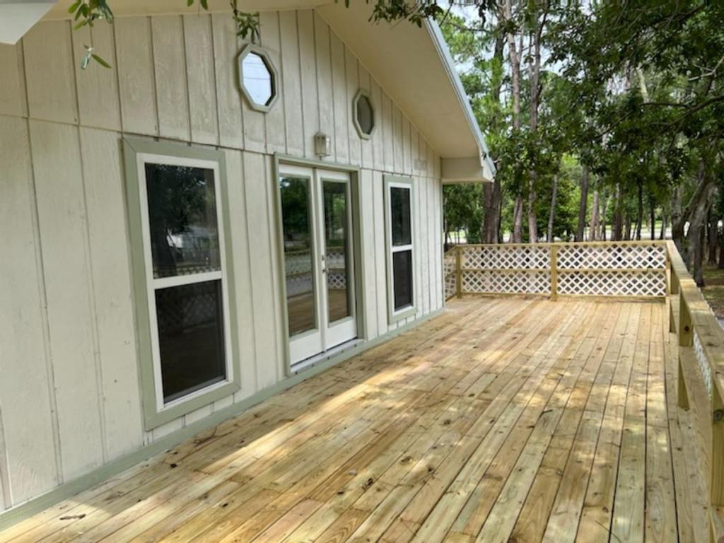 a porch of a house with a wooden deck at Playing Hookie LLC in Dauphin Island