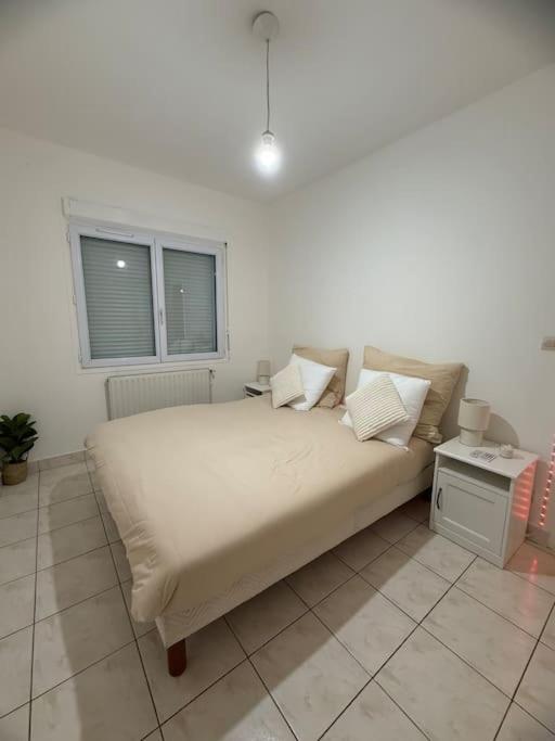 a large bed in a room with a window at Appartement au Plessis-Robinson in Le Plessis-Robinson