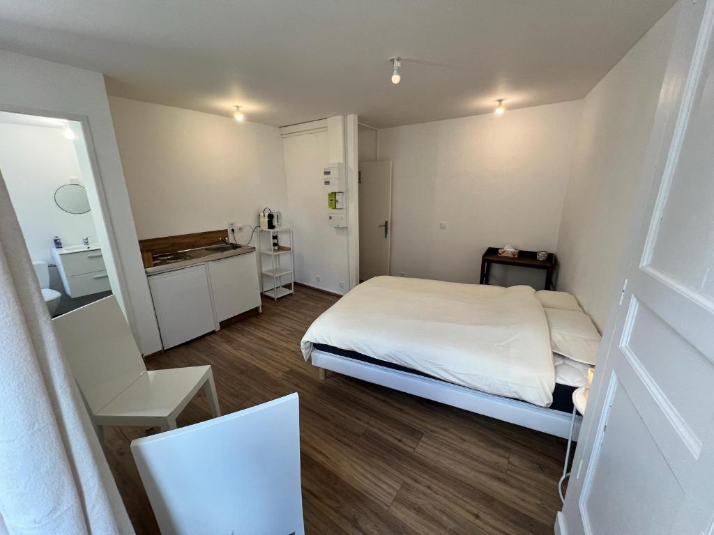 a small room with a bed and a kitchen at Chez Kiki in Felletin