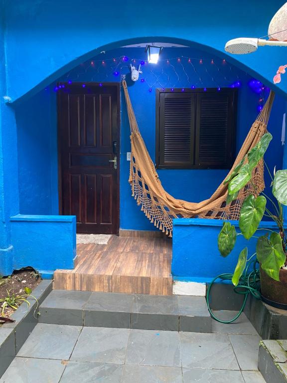 a blue house with a hammock in front of it at BLUE HOUSE CONEXÃO ILHA GRANDE in Abraão