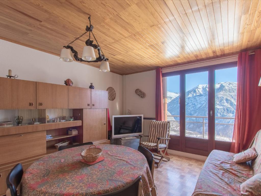 a living room with a table and a view of a mountain at Les Marmottes 2 N 69 - 3P7 in Orcières
