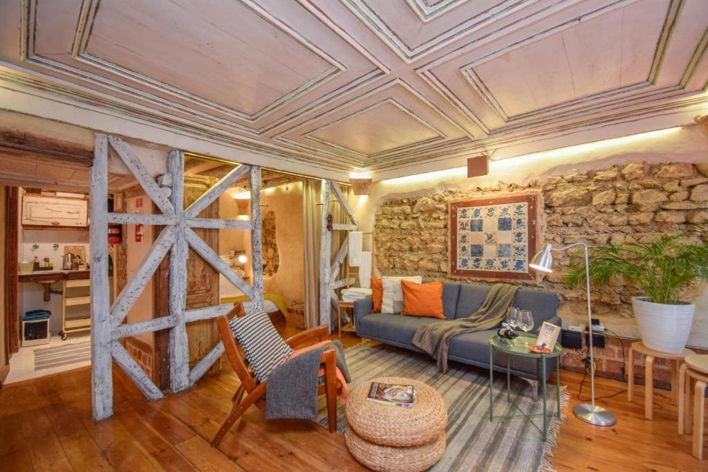 a living room with a couch and a stone wall at Alfama Charming and Rustic in Lisbon