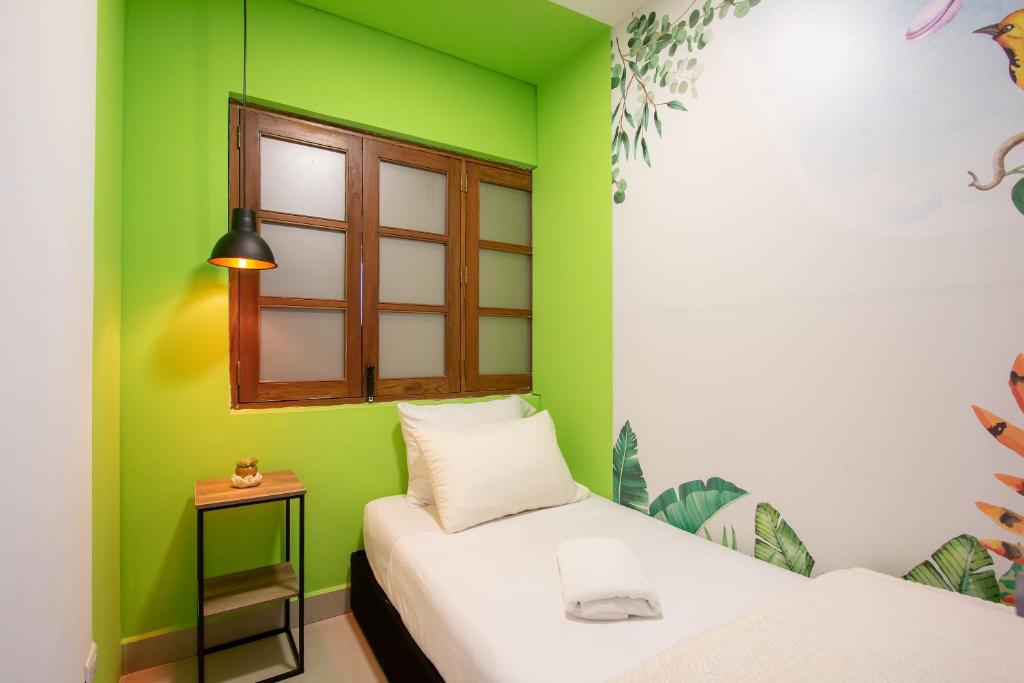 Camera verde con 2 letti e finestra di Parceros Med Hostel a Medellín